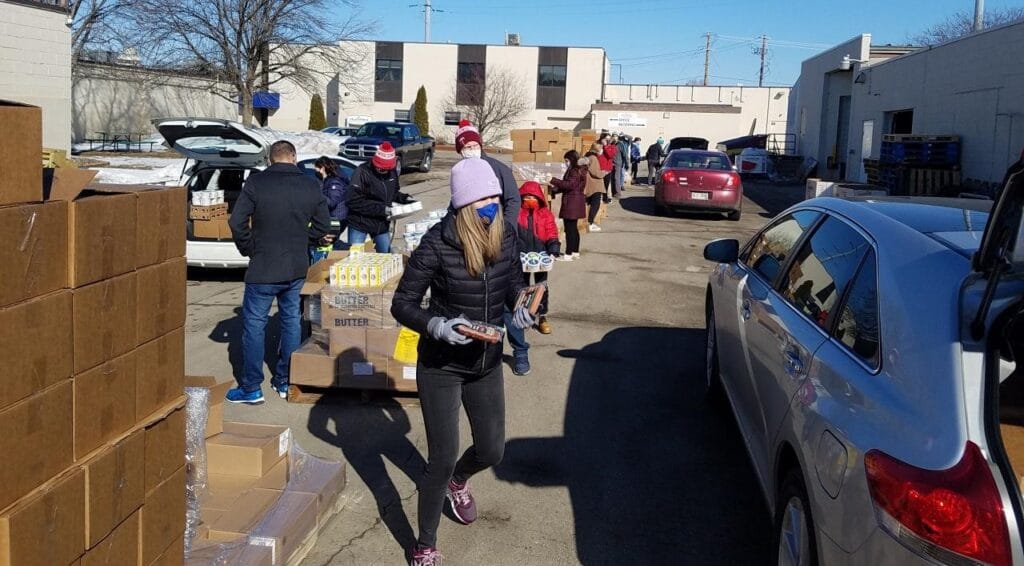 volunteers loading cars with food